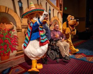 people smiling and dancing; hugging disney characters