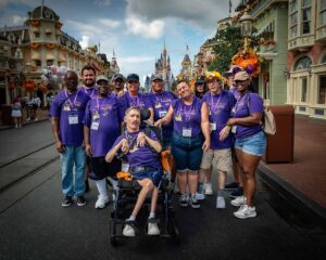 people in matching purple shirts smiling at disney world