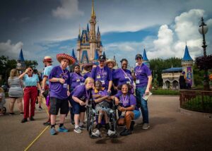 people in matching purple shirts smiling at disney world