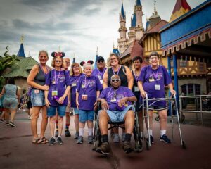 people in matching purple shirts smiling at disney world