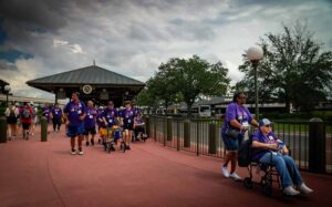 group of people walkinginto disney world - some in wheelchairs