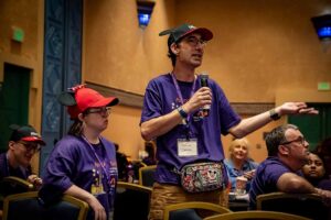 man in purple shirt with microphone