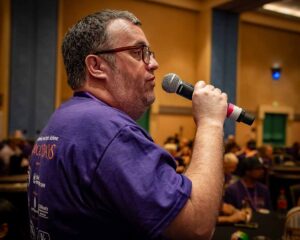 man in purple shirt with microphone