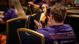 back of lady in purple shirt clapping