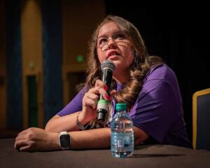 lady in purple shirt with microphone