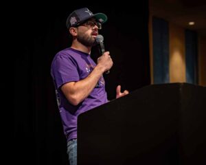 man in purple shirt with microphone