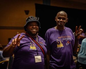 people smiling in matching purple shirts